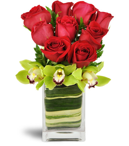 Exotic Rose Orchid Vase™. An arrangement by Avenue Flowers and Gifts. Red roses are surrounded by exotic Cymbidium orchids in a glass vase..